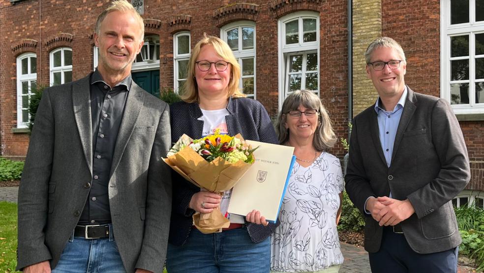 Jubilarin Tanja Münch mit (von rechts) Bürgermeister Heiko Abbas, Elke Wodtke (Kindergarten »Bunte Welt«) und Hermann Welp (Erster Stadtrat). © Foto: Stadt Weener