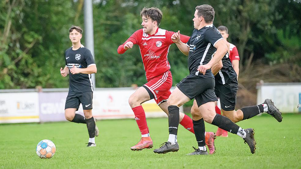 Felix Lange (rotes Trikot) glich gegen den FC Loquard zweimal aus - am Ende siegten dennoch die Gäste aus der Krummhörn.  © Foto: Bruins