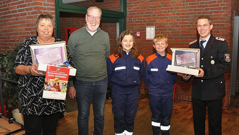 Das zeigt: (von links) Gerlinde Robbe (Weihnachten im Schuhkarton), Curt Weber (Vorsitzender der Heimatbühne Bingum) sowie Milia Raske, Finn Lünemann und Matthias Haakem, Leiter der Jugendfeuerwehr Bingum. © Wolters