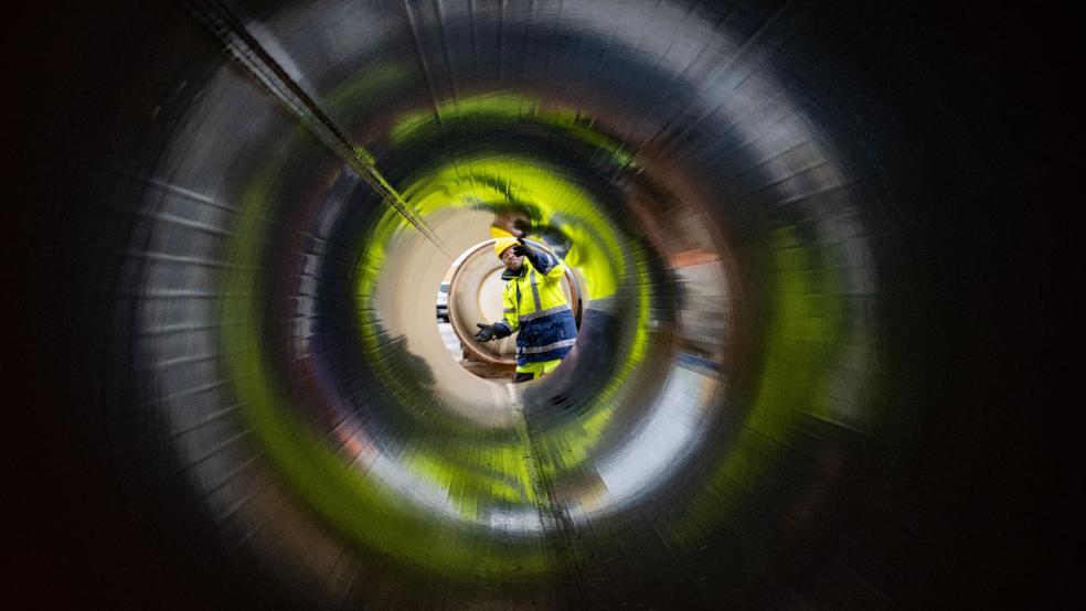 Ein Mitarbeiter des Gasnetzbetreibers Gascade prüft ein tonnenschweres Rohr für eine Anbindungsleitung. © Sauer (dpa/Symbolfoto)