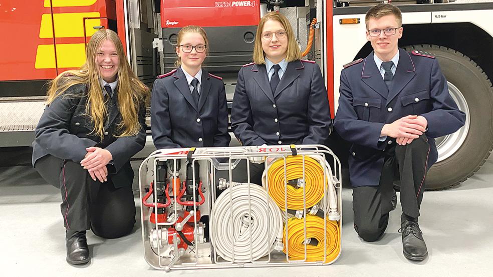 Befördert und neu aufgenommen wurden (von links) Celine Schlüter (Feuerwehrfrau), Vanessa Swart (Oberfeuerwehrfrau), Lisa Rose (Erste Hauptfeuerwehrfrau) und Markus Klamert als neues Mitglied und Feuerwehrmann-Anwärter. Neu ist auch ein Schlauchtragekorb. Auf dem Foto fehlt Michelle Gräfe (Feuerwehrfrau).  © Foto: Kuper