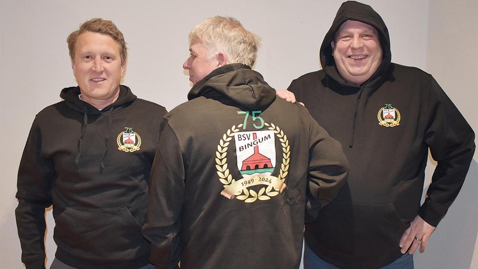 Jann Ubbens (von links), Carsten Kempen und Tobias Borsum präsentieren die Kapuzenpullover zum 75-Jährigen des BSV.  © Foto: privat