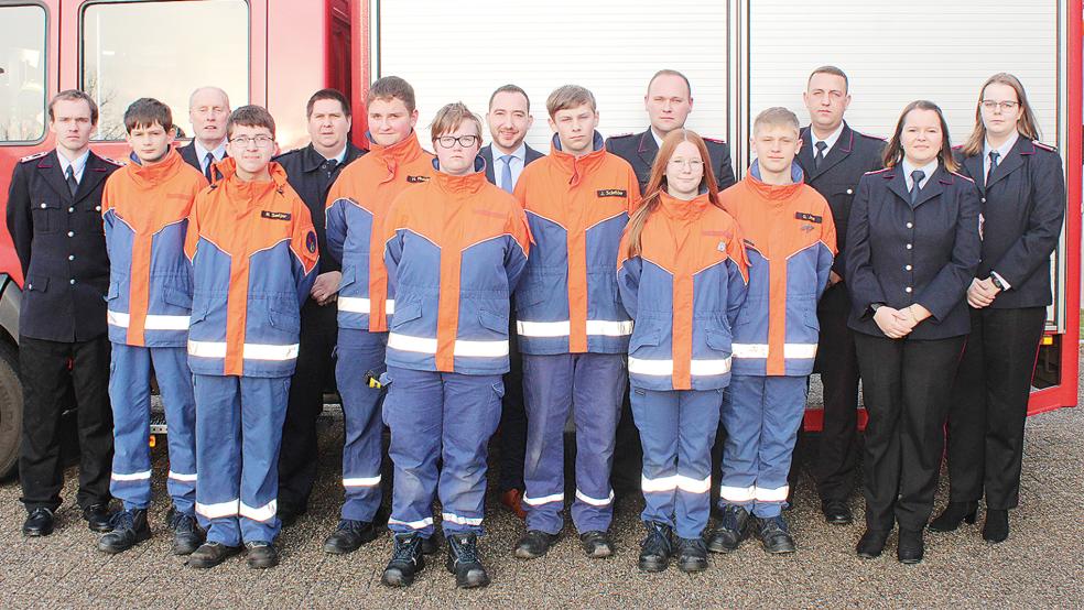 Zur Hauptversammlung kamen auch (hintere Reihe von links) Betreuer Timo Röskens, Stadtjugendfeuerwehrwart Ewald Freese, der stellvertretende Kreisjugendfeuerwehrwart Jens Schmitt, der stellvertretende Bürgermeister Nico Bloem, der stellvertretende Stadtbrandmeister Steffen Voss, Ortsbrandmeister Stefan Siemens, die stellvertretende Jugendfeuerwehrwartin Janna Schmehl und Betreuerin Nicole Groen.  © Foto: Rand (Feuerwehr)