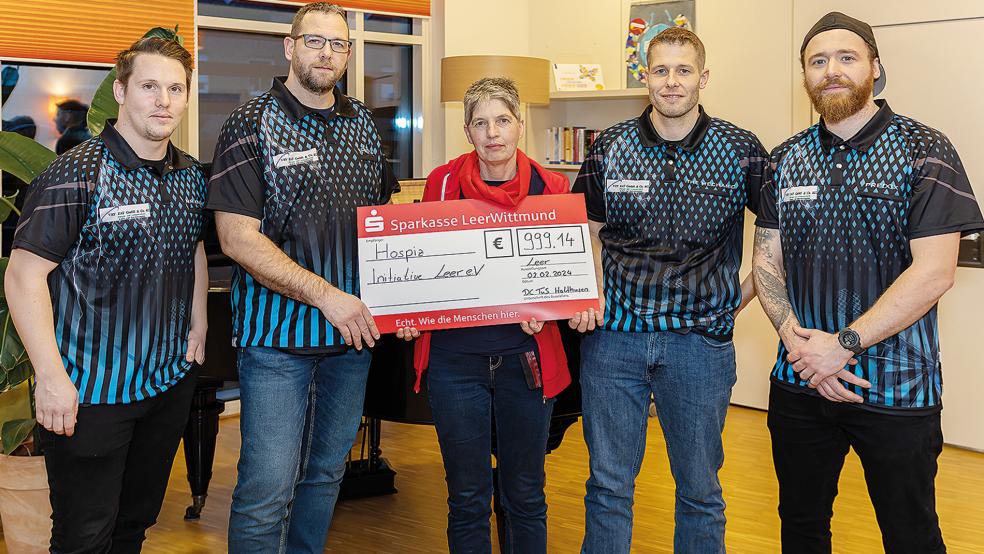 Patrick Meyer (von links), Matthias Gernand vom DC TuS Holthusen übergaben Marlies Smidt von der Hospiz-Initiative Leer den symbolischen Scheck üver 999,14 Euro gemeinsam mit Markus Gernand und Dennis Reck.  © Foto: Jungeblut