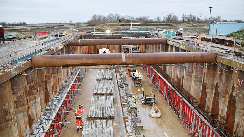Zwei rund 35 Meter lange, vier Meter breite und 1,6 Meter hohe Betonkanäle werden durch den Deich verlegt. Meterhohe Spundwände sind in den Boden gerammt worden, um die Baustelle zu sichern.  © Foto: Ammermann