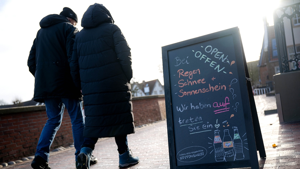 Touristen laufen an den Cafés am Hafen von Greetsiel entlang. Die Zeugnisferien in Niedersachsen von Mittwoch an nutzen viele Familien für einen Kurzurlaub um die Ecke.  © dpa