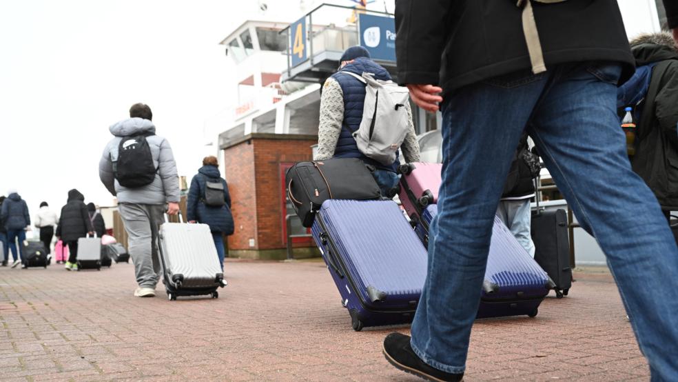 Ansturm auf die ostfriesischen Inseln: Urlauber laufen am Anleger in Norddeich mit ihrem Gepäck zur Insel-Fähre. © Penning (dpa)