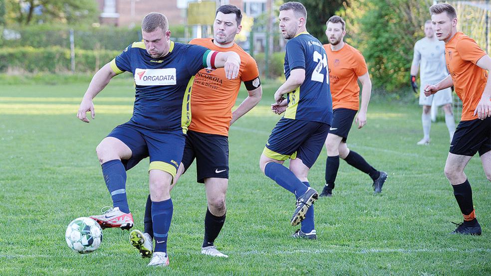 Defensiv ließen Wymeer-Boens Kapitän Dennis Klock (orangenes Trikot links) und sein Team gegen Bastian Fischer (links) und die SG Leer nichts zu. Vorne brachte Klock seine Elf in Führung.  © Foto: Born