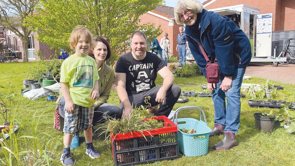 Helga van Hoorn (rechts) gibt Matina und Hannes Mörtel Tipps zu den gekauften Stauden für den Garten in Möhlenwarf, Tochter Nia Mörtel will beim Pflanzen helfen.  © Foto: Kuper