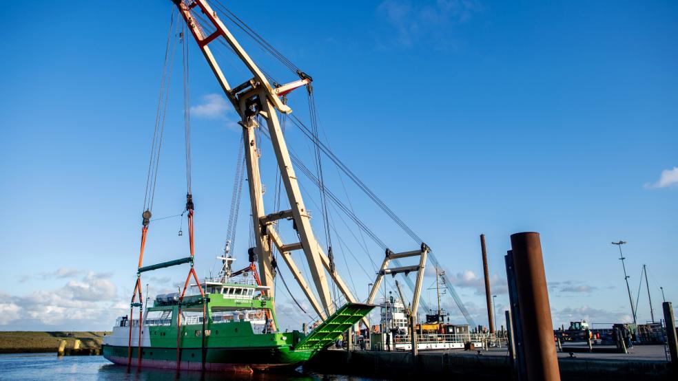 Der Schwimmkran »Enak« hebt die gestrandete Inselfähre zurück in das Hafenbecken.  © Dittrich (dpa)