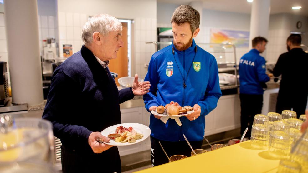 James O’Driscoll aus Irland und Riccardo Manieri aus Italien unterhalten sich im Frühstücksraum der Jugendherberge DJH Resort Neuharlingersiel, die als Unterkunft für die Teilnehmerinnen und Teilnehmer der Europameisterschaft im Boßeln und Klootschießen genutzt wird.  © Dittrich (dpa)