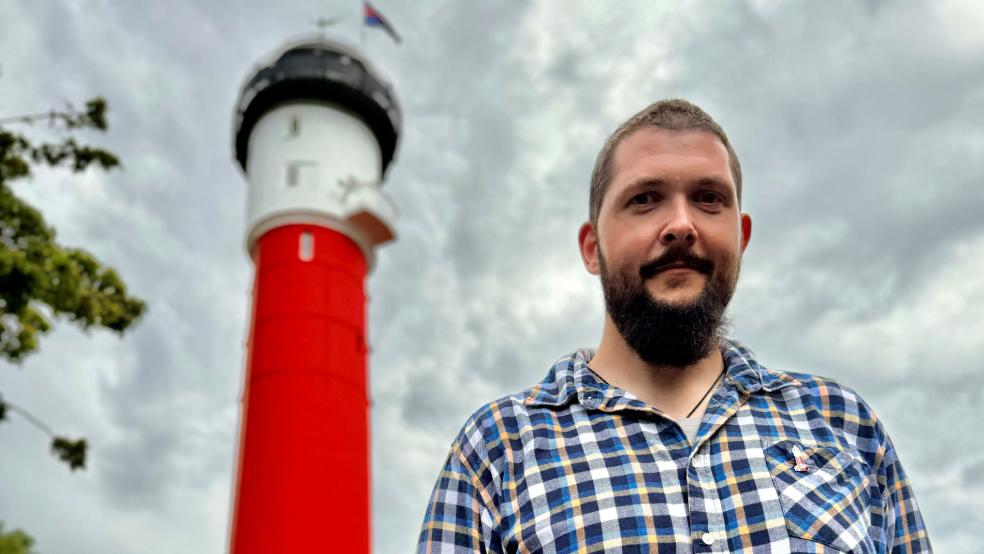 Daniel Jochheim, neuer Leuchtturmwärter auf der Nordseeinsel Wangerooge, steht vor dem denkmalgeschützten Alten Leuchtturm.  © Hüneke (dpa)