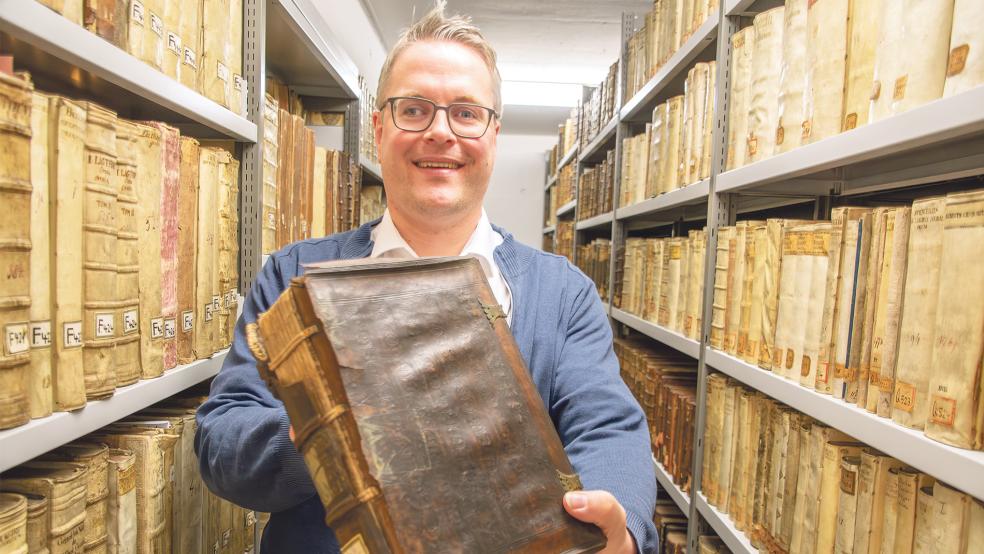 Dr. Heiko Suhr zeigt ein beschädigtes Buch aus der Bibliothek von Christoph Friedrich von Derschau.  © Foto: Landschaft