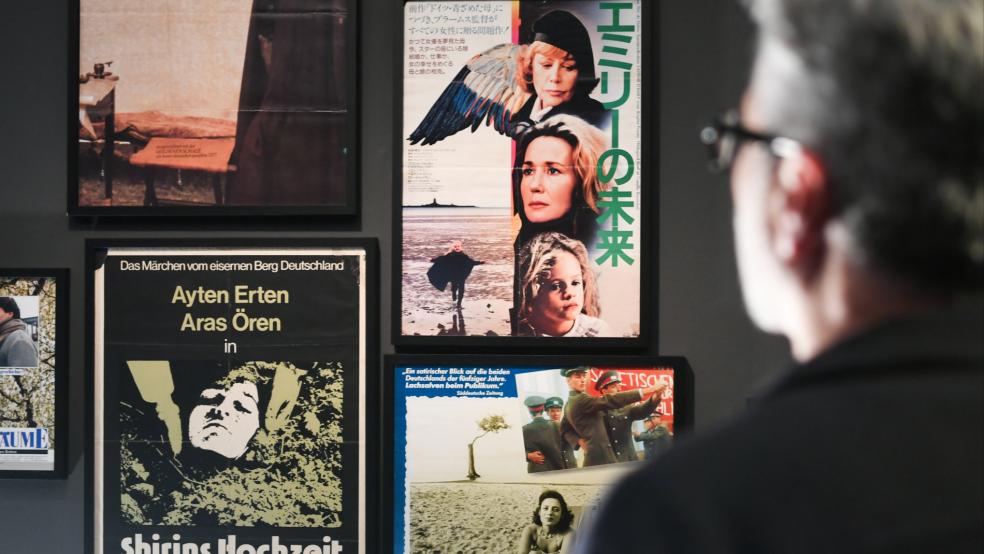 Der Filmemacher und Kurator der Ausstellung, Ayhan Salar, schaut auf Filmplakate zu Werken von Helma Sanders-Brahms.  © Stock (dpa)