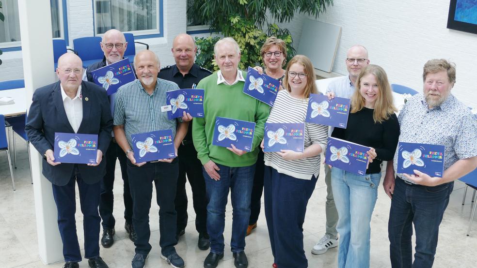 Die »Eltern« von Fritz Filapper, Brigitte Kleemann (vorderen Reihe Dritte von rechts) und Heinz Kleemann (links daneben im grünen Pullover), freuen sich gemeinsam mit den Verantwortlichen von Brandkasse, Plattdüütskbüro und Oostfreeske Taal über 25 Jahre erfolgreiche Zusammenarbeit.  © Foto: Jürgens