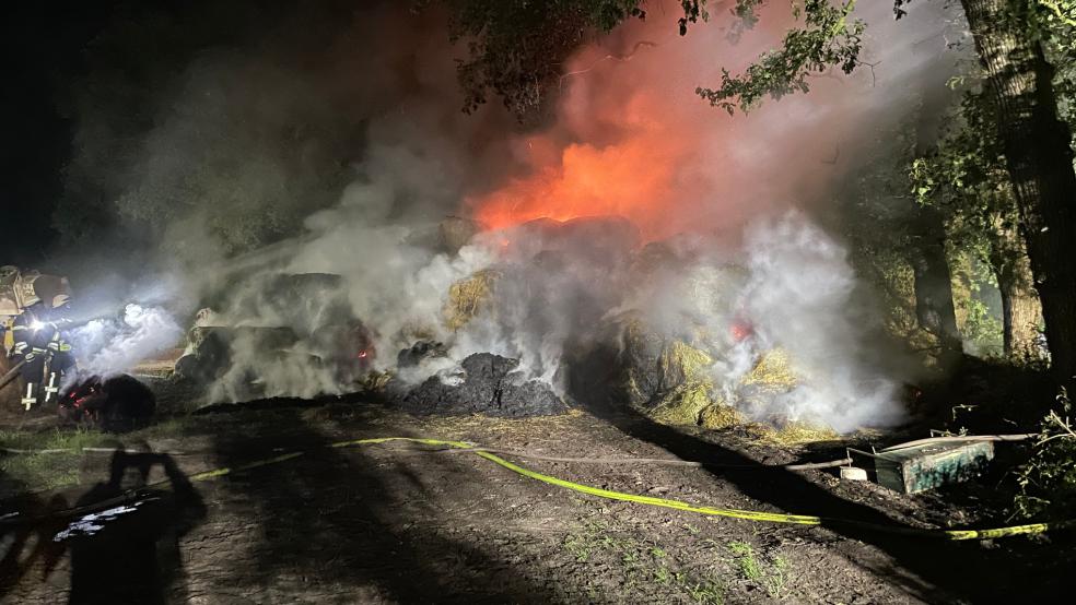 Mit mehreren Strahlrohren löschten die Einsatzkräfte der Feuerwehr die brennenden Heuballen ab. © Feuerwehr