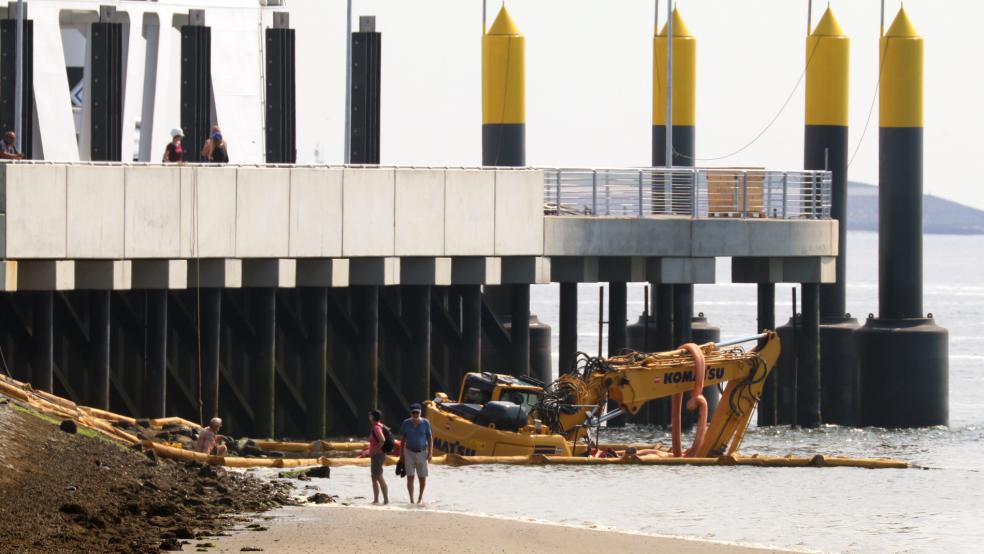 Etliche Versuche, den Bagger bei Niedrigwasser zu bergen, waren zunächst erfolglos geblieben. Deshalb waren Ölsperren ausgelegt worden. © Bartels (dpa)