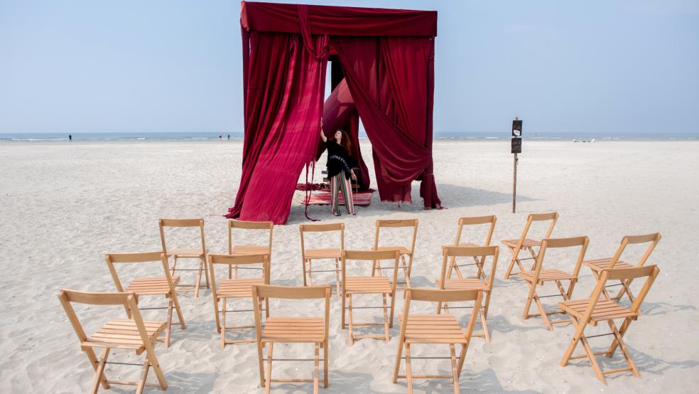 Iulia Grigoriu, rumänische Theaterregisseurin mit Wohnsitz in Berlin, bereitet am Strand der Insel einen Theatervorhang für die Aufführung vor.  © Dittrich (dpa)