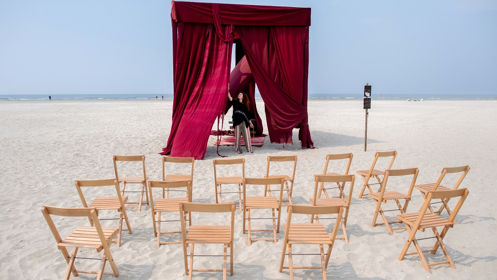 Iulia Grigoriu, rumänische Theaterregisseurin mit Wohnsitz in Berlin, bereitet am Strand der Insel einen Theatervorhang für die Aufführung vor.  © Dittrich (dpa)