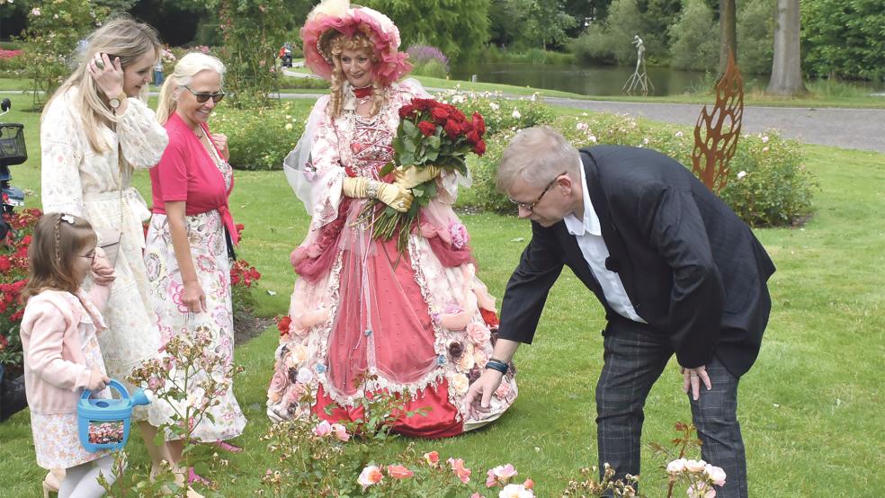 Auf den Namen »Maya Wildevuur« wurde auf dem »Groenmarkt« im Winschoter Rosarium eine orange-gelb-blühende Rose zur Erinnerung an die verstorbene Künstlerin getauft. Beigeordneter Jurrie Nieboer (rechts) und Emmy Folmer (Mitte) von der Gemeinde Oldambt leiteten die Zeremonie.  © Kuper