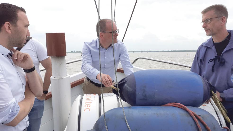 Nico Bloem (von links) und Grant Hendrik Tonne informierten sich bei Johann Robbe auch bei einer Kutterfahrt zum Sperrwerk über die Situation im Ditzumer Hafen.  © Foto: Berents