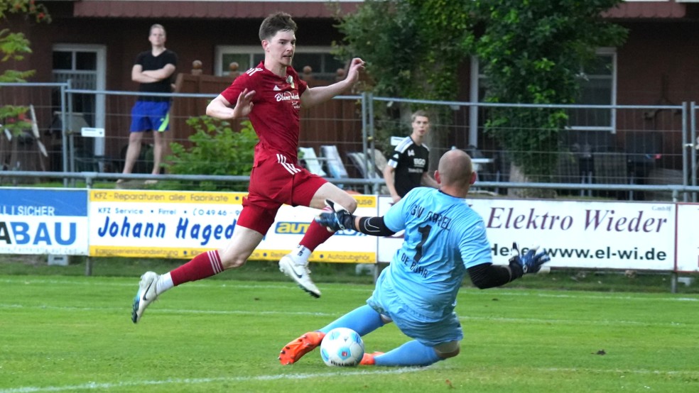 Pewsums Derk Schoneboom schiebt den Ball an Firrels Pascal Hötzel vorbei zum 1:1 ins Netz. © Mennenga