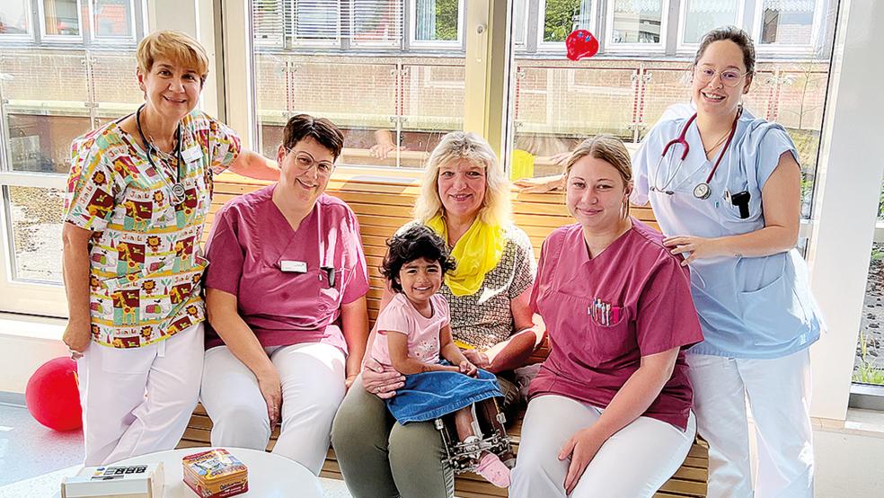 Mahsa sitzt auf dem Schoß von Hannelore Tolzmann vom Besuchsdienst des Vereins »Hilfe für Kinder in Not«. Das Team der Kinderstation (von links) mit Oberärztin Tatjana Repinska, Kinderkrankenschwester Silvia Lampen, Gesundheits- und Kinderkrankenpflegerin Sarah Lindemann sowie Assistenzärztin Lorena Alderete hat die kleine Mahsa ins Herz geschlossen.  © Foto: Marien Hospital