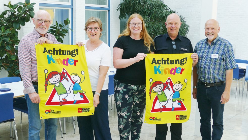 Mehr Sicherheit dank erhöhter Aufmerksamkeit: Die Verantwortlichen der ostfriesischen Verkehrswachten (von rechts) Hans-Friedel Walther (Aurich), Hans-Günter Jelting (Leer), Daniela Bokker (Wittmund) sowie Hajo Reerhemius (Norden) und Signe Foetzki von der Brandkasse (Zweite von links) präsentieren die neuen Banner.  © Foto: Jürgens