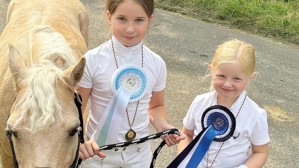 Die vierjährige Tilda Winzenborg (von rechts) aus Bunde nach ihrem ersten Turnierstart und die siebenjährige Leni Klüver aus Möhlenwarf mit deren Pony Wallach Scaper.  © Foto: privat