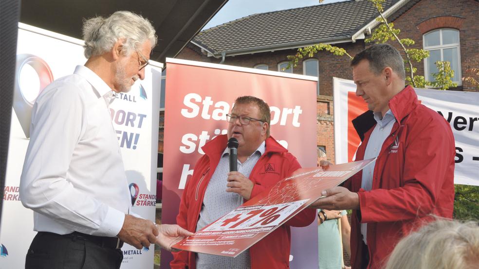 An den Präsidenten des Arbeitgeberverbandes Nordmetall, Folkmar Ukena, überreichten der 1. Bevollmächtigte der IG Metall Leer-Papenburg, Thomas Gelder, und der 2. Bevollmächtige der IG Metall Emden, Thomas Preuß (von links), eine Tafel mit den Tarif-Forderungen.  © Foto: Wolters