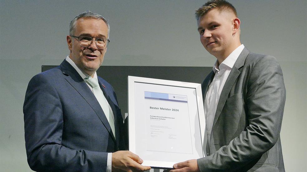 Feinmechanikermeister Sebastian Schulze (rechst) aus Südbrookmerland wurde bester seines Jahrgangs und erhielt dafür eine besondere Auszeichnung vom Jörg Dittrich.  © Jürgens