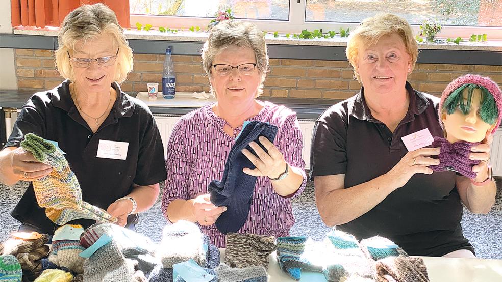 »Alles für die kalte Jahreszeit«, damit preisen (von links) Marianne Fröhling, Hannelore Buntjer und Hilde Heijen ihre selbstgestrickten Socken und Mützen an.  © Fotos: Kuper