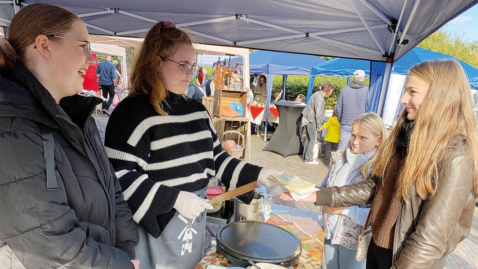 Amelie und ihre kleine Schwester Elina aus Jemgum probierten Crêpes mit Nutella, zubereitet von Luna-Marie (links) und Maya-Sophie Blümel.  © Fotos: Kuper 