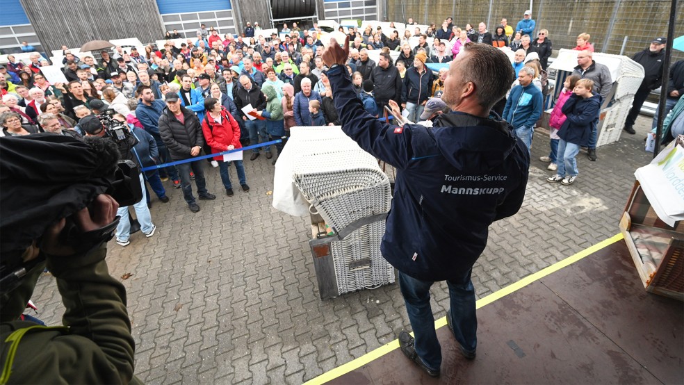 Strandchef Harald Lübbers versteigert einen Strandkörben. Vor der Versteigerung können sich Interessierte die Strandkörbe anschauen. Für den Abtransport müssen die Käufer selbst sorgen.  © Foto: dpa/Penning