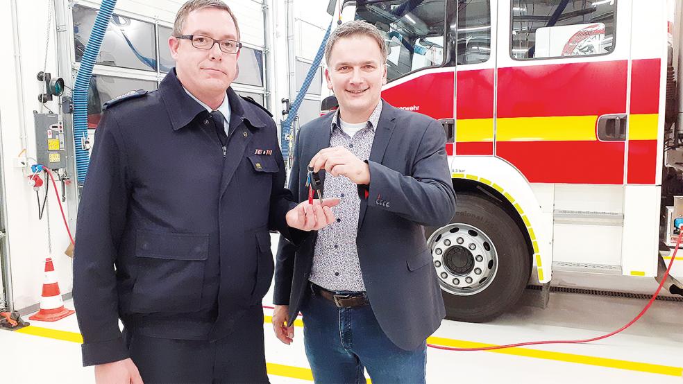 Bürgermeister Uwe Sap (rechts) überreichte ganz offiziell den Schlüssel des neuen Gerätewagens an Ortsbrandmeister Hans-Hermann Leemhuis. Das Fahrzeug ist flexibel einsetzbar und mit dem Bunder Wappen verziert.  © Foto: Berents