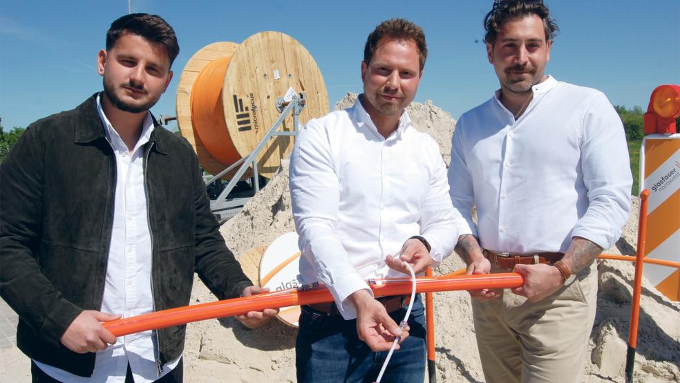 Das Leerrohr, das Florian Nierke von Glasfaser Nordwest hier in der Hand hält, führt in Richtung Haus. Links Omer Kosulta, rechts David Braun, beide sind für Salko Bau tätig.  © Foto: Hoegen