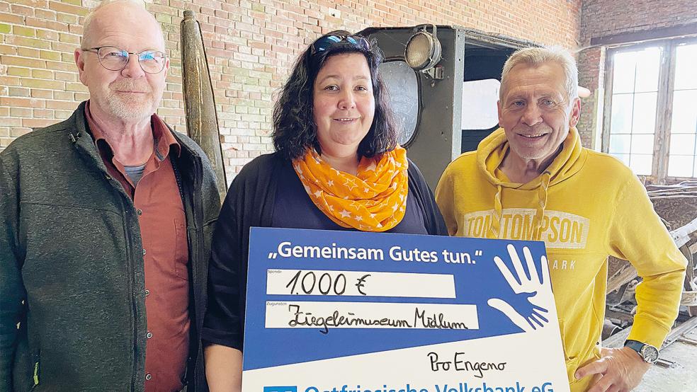 Vor der alten Lorenbahn überreichte ProEngeno-Geschäftsführerin Bianca Meinders den Spendenscheck an den Vorsitzenden Wilfried Voß (rechts) und Kassenwart Bernd Oppler vom Ziegeleiverein Jemgum.  © Foto: Ziegeleiverein