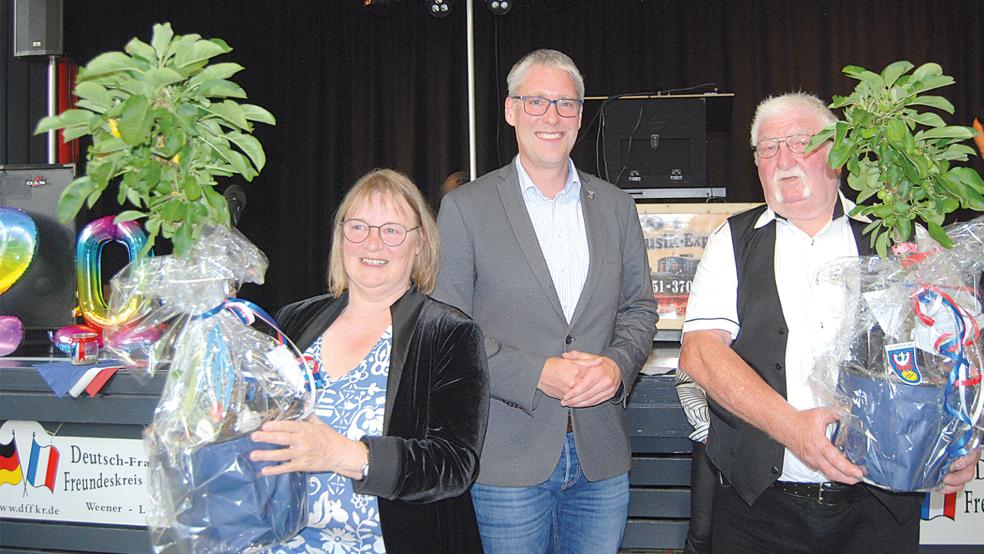 Das sind die beiden Apfelbäume, die Anna Canovas als Vorsitzende des Deutsch-Französischen Freundeskreises und Roger Hamelin als Vertreter der Gästegruppe aus Les Pieux am Sonnabend von Bürgermeister Heiko Abbas (Mitte) als Geschenk überreicht bekam.  © Foto: Hoegen