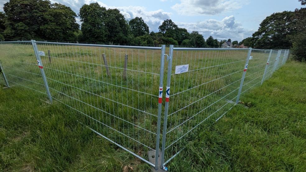 Der Bauzaun rund um das Grundstück hinter der Kleintierhalle am Beningaweg in Weener steht schon. © Szyska