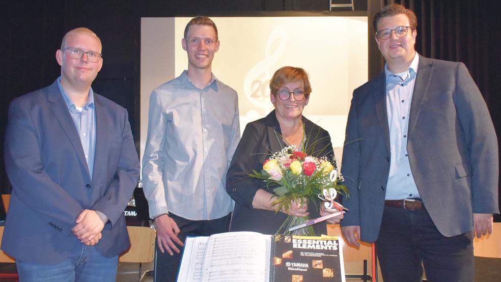 Blumen gab es für Christiane Meyer, die seit 20 Jahren die Bläserklassen der Oberschule Weener unterrichtet. Mit ihr auf dem Foto sind die Musiklehrer (von links) Jens Sonntag, Henning Roolfs und Gerd Zimmermann.  © Foto: Kuper