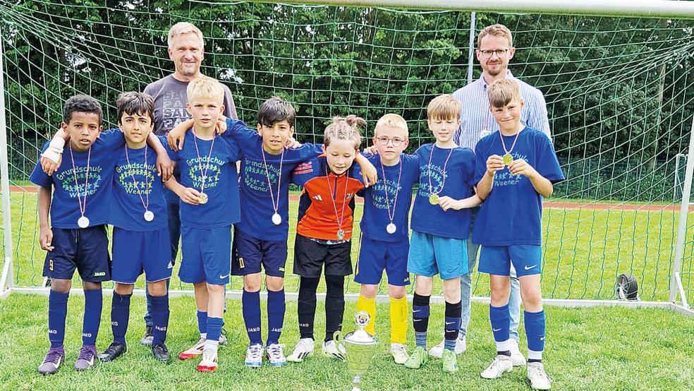 Die Fußballer des TuS Weener freuen sich mit Betreuer Bernd Feenders und Lehrer Heiko Engberts.  © Foto: privat
