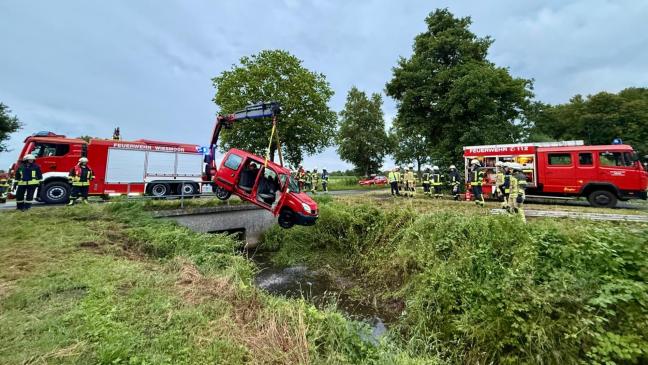 Feuerwehrleute befreien Mann aus Auto im Graben