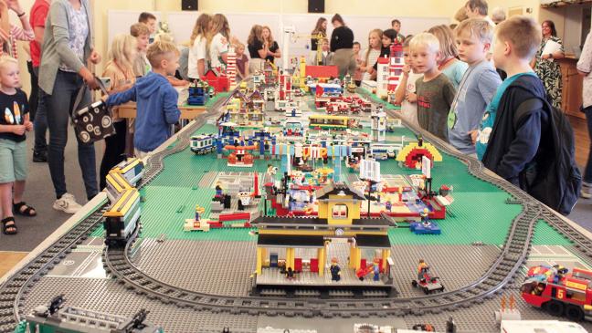 Kinder bauen eine Stadt aus Lego-Steinen