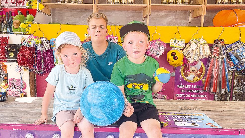 Einen blauen Ball gewann Finn Wurps (5) aus Jemgum beim Werfen auf Dosenpyramiden am Stand von Stephan Wilken jr. Darüber freute sich auch seine kleine Schwester Mena (2), zumal das Ballspielen zu zweit mehr Spaß macht als allein.  © Foto: Kuper
