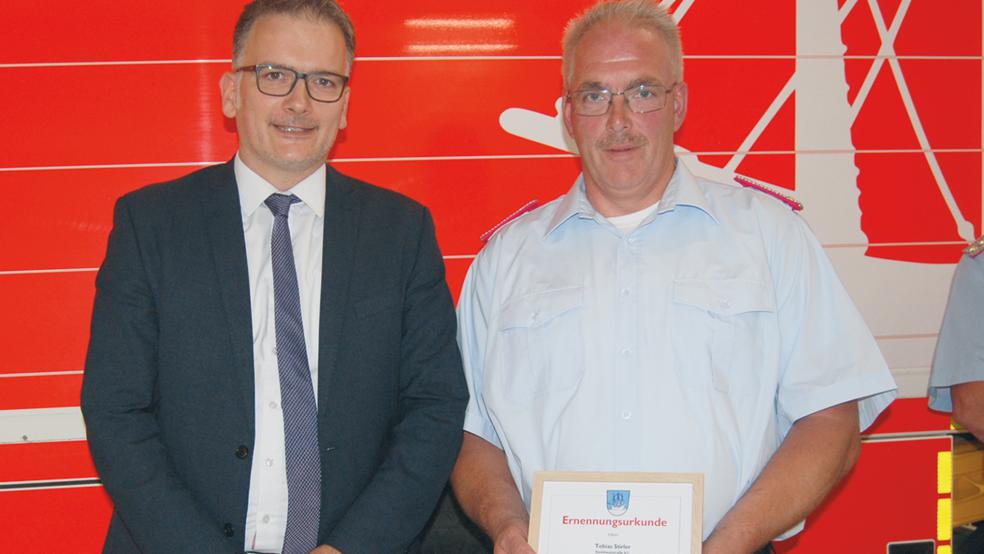 Bürgermeister Uwe Sap überreichte Tobias Stirler seine Ernennungsurkunde für seine Aufgabe als stellvertretender Gemeindebrandmeister.  © Foto: Hoegen