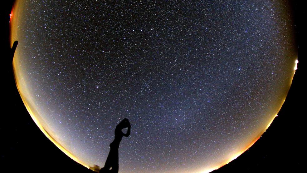 Die Skulptur »De Utkieker« zeichnet sich vor dem Sternenhimmel über der Nordseeinsel Spiekeroog ab. Spiekeroog ist offizielle Sterneninsel. © Foto: Hänel/dpa