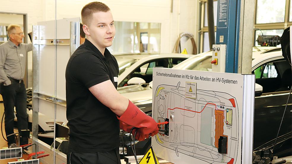 Kfz-Mechatroniker Torge Rosenbäck aus Emden prüft während des Landeswettbewerbs in Aurich die Spannung an einer Modellwand eines Elektrofahrzeuges.  © 