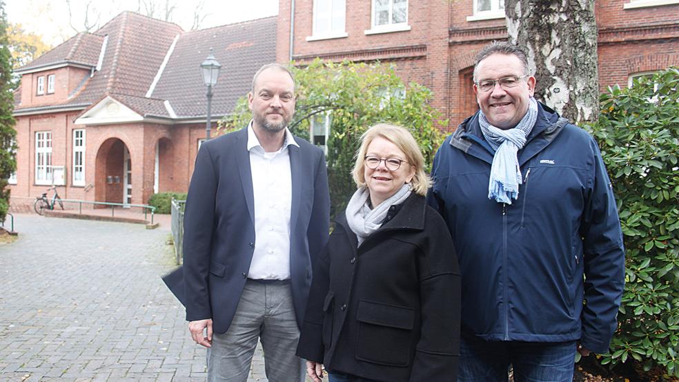 Das Gemeindehaus der evangelisch-reformierten Kirchengemeinde Weener (hinten links) und das historische Pfarrhaus (rechts) werden zu einem großen und zeitgemäßen Gemeindezentrum verschmelzen. Architekt Karsten Woltermann (vorne links), Traute Schilling von der evangelischen Landeskirche und Detlef Troff vom Kirchenvorstand stellten die Pläne vor.  © Foto: Busemann