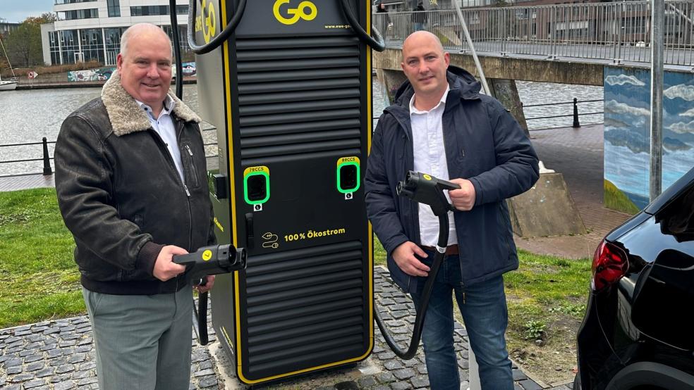 Präsentieren die Ladesäule an der Kupenwarf in Leer: Bürgermeister Claus-Peter Horst und Stefan Becker von der EWE Go GmbH.  © Stadt Leer