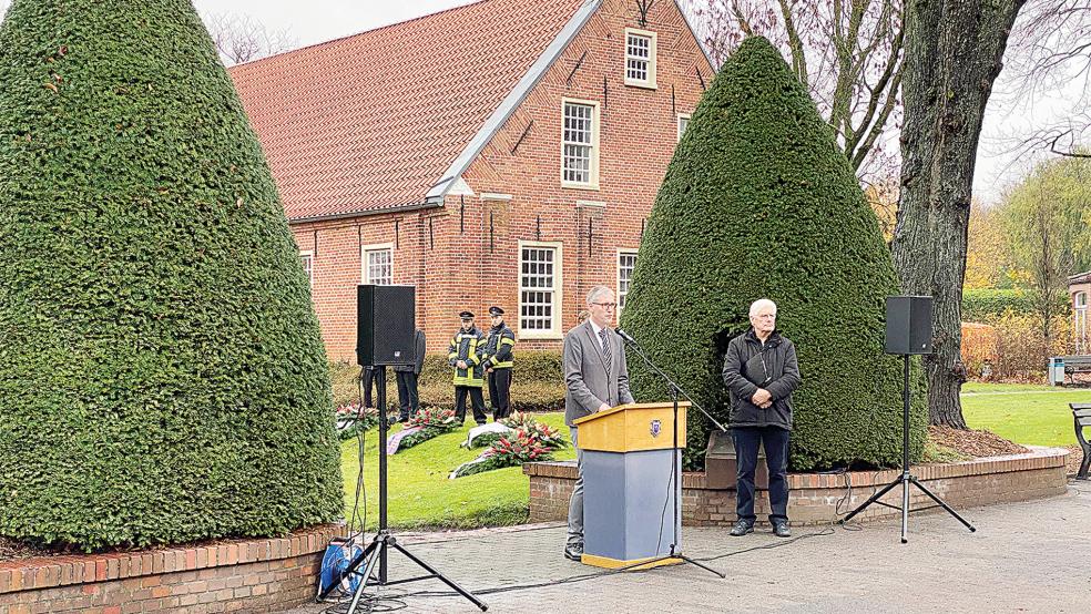 Am Denkmal in der Neuen Straße in Weener sprachen Bürgermeister Heiko Abbas (am Pult) und Pastor Bernd Passarge anlässlich der Gedenkstunde zum Volkstrauertag.  © Fotos: Kuper